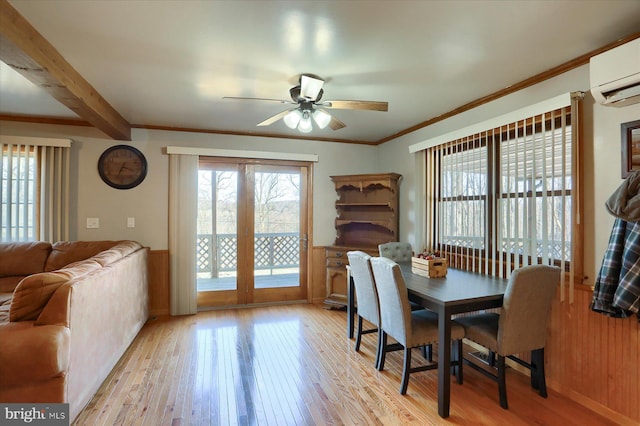 dining room featuring beam ceiling, light wood-style flooring, an AC wall unit, wainscoting, and crown molding