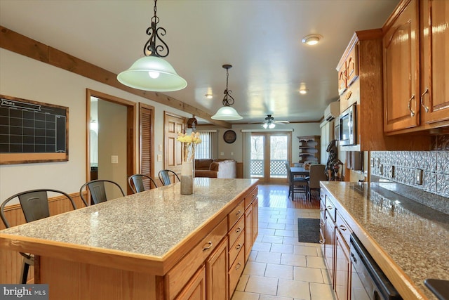 kitchen featuring a center island, tile counters, open floor plan, pendant lighting, and dishwasher