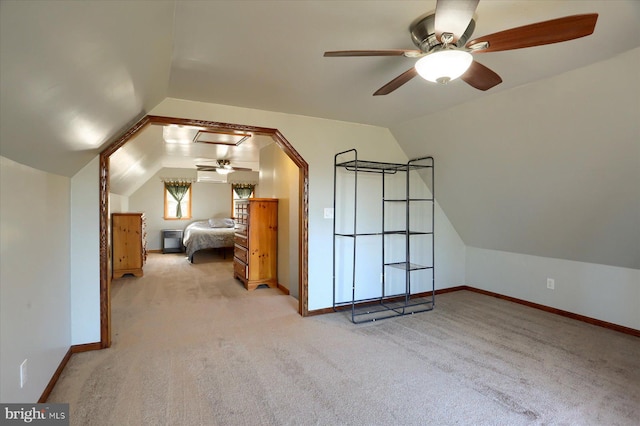 unfurnished bedroom featuring lofted ceiling, baseboards, and light carpet