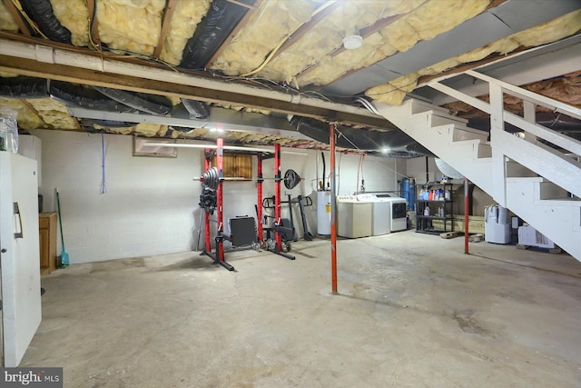 unfinished basement with water heater, stairway, and independent washer and dryer