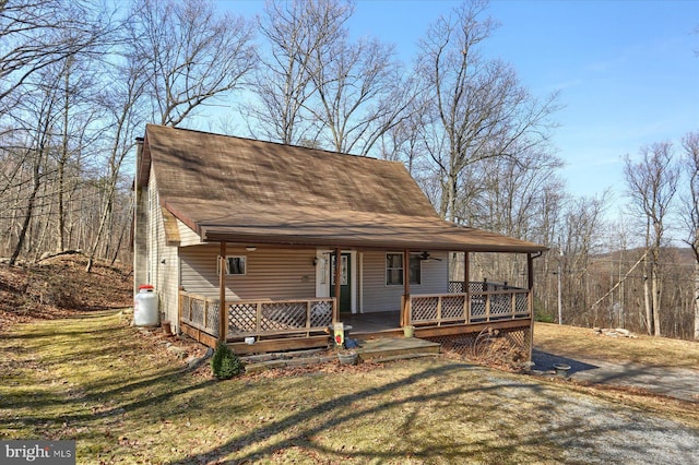 view of front facade with covered porch, a front yard, and a shingled roof