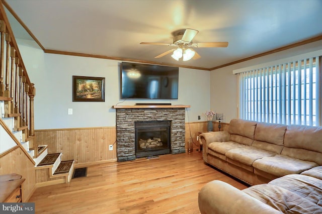 living area with a wainscoted wall, stairway, crown molding, and visible vents