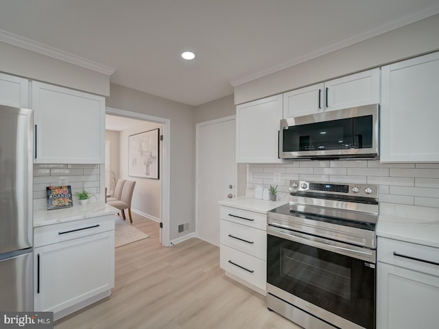 kitchen featuring baseboards, light wood-type flooring, decorative backsplash, white cabinets, and stainless steel appliances