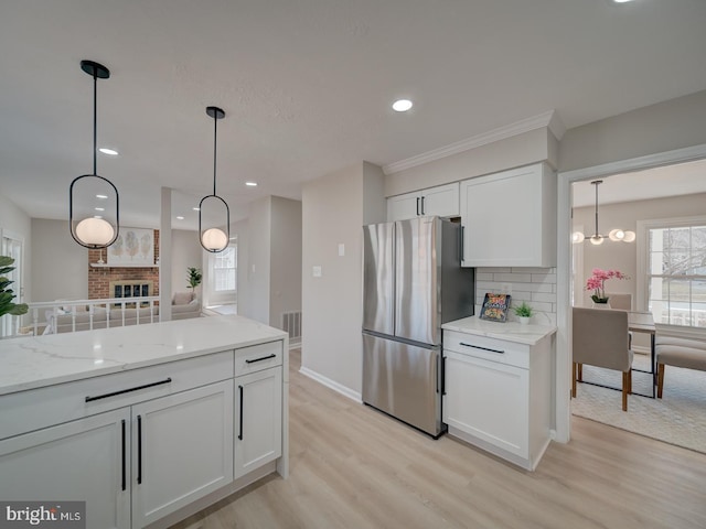 kitchen featuring visible vents, tasteful backsplash, freestanding refrigerator, white cabinets, and light wood finished floors