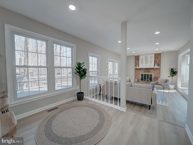 living area with recessed lighting, visible vents, wood finished floors, and a fireplace