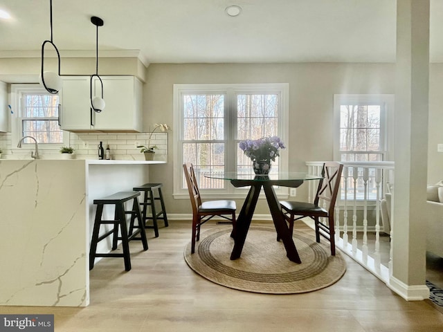 dining space featuring light wood-type flooring and baseboards