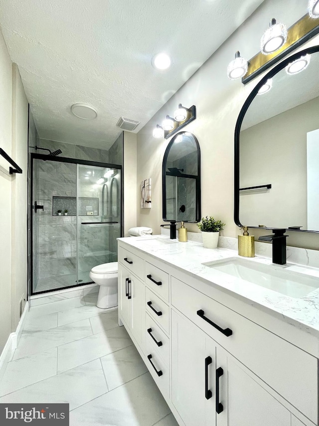 full bathroom with a stall shower, toilet, marble finish floor, and a sink