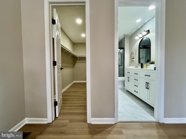 walk in closet featuring light wood-type flooring and visible vents