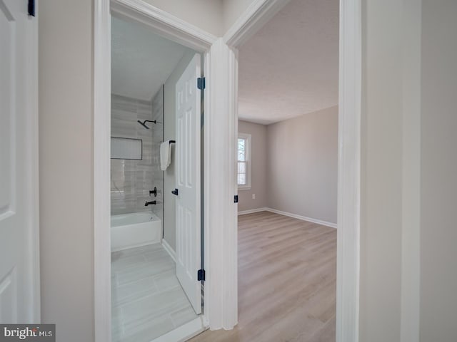 hallway with wood finished floors and baseboards