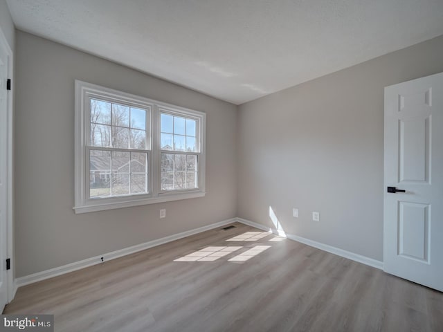 unfurnished room with wood finished floors and baseboards