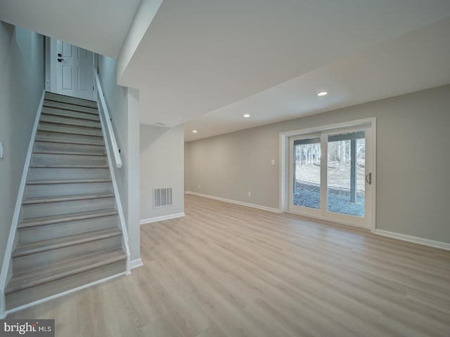 interior space featuring visible vents, light wood-style flooring, stairs, and baseboards