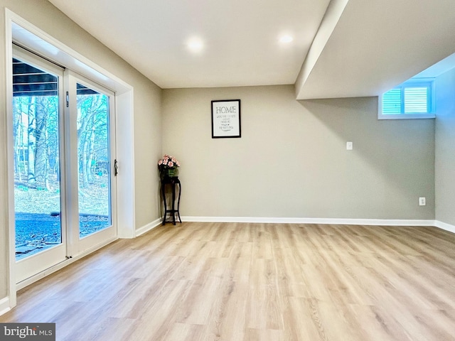 spare room featuring baseboards and light wood-style flooring