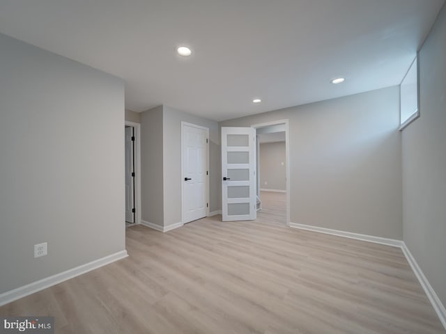 empty room featuring recessed lighting, light wood-type flooring, and baseboards