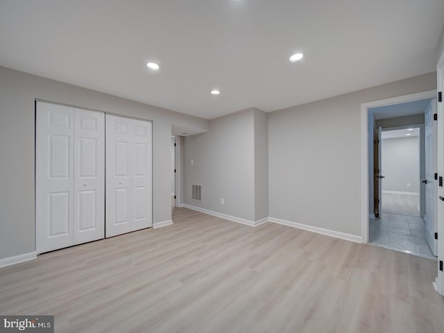 unfurnished bedroom featuring visible vents, baseboards, recessed lighting, light wood-style floors, and a closet