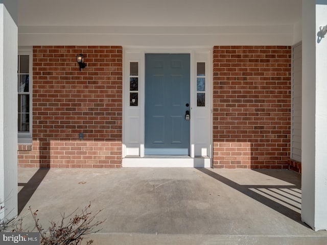 property entrance featuring brick siding