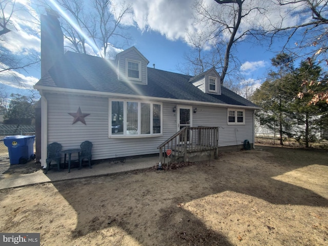 rear view of property featuring a shingled roof