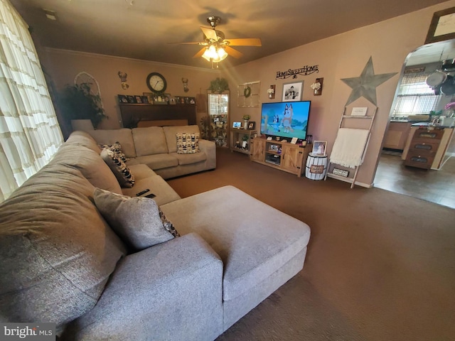 living area with carpet, arched walkways, a ceiling fan, and ornamental molding