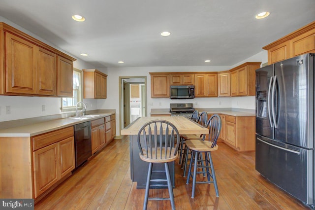 kitchen featuring stainless steel appliances, light wood-style floors, and light countertops