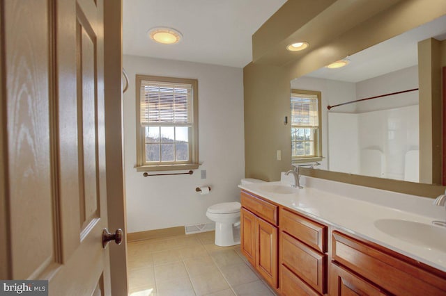 full bathroom featuring tile patterned floors, toilet, walk in shower, and a sink