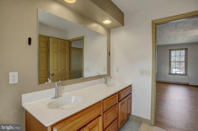 full bath with a sink, visible vents, baseboards, and double vanity