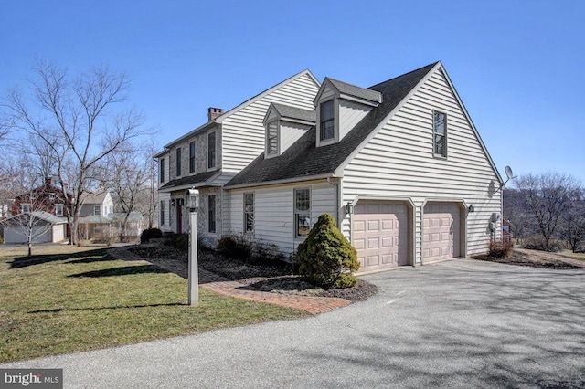 view of home's exterior with aphalt driveway, an attached garage, and a yard