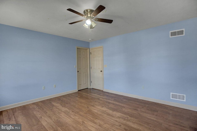 empty room with visible vents, ceiling fan, baseboards, and wood finished floors