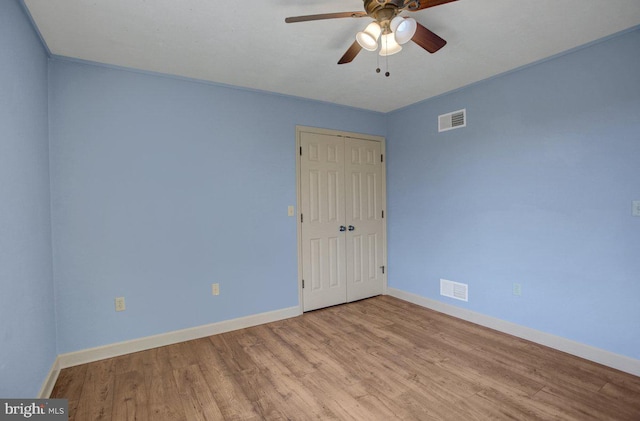 spare room featuring visible vents, baseboards, and wood finished floors