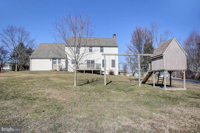 back of property with a chimney, a playground, and a yard