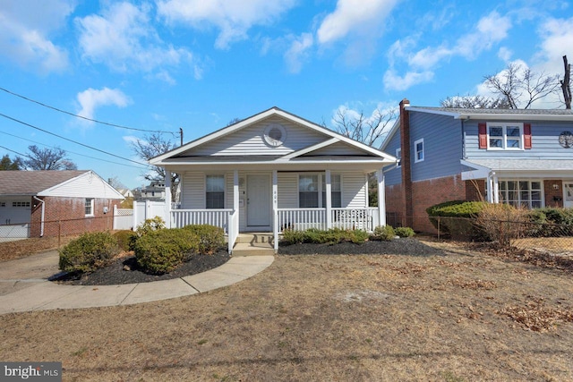 bungalow-style house with a porch and fence