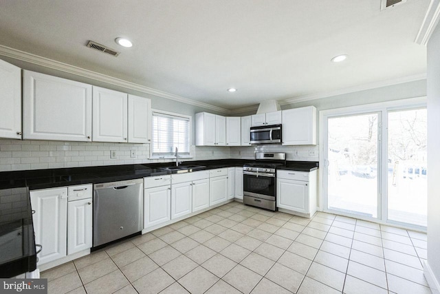 kitchen featuring visible vents, a sink, decorative backsplash, ornamental molding, and stainless steel appliances