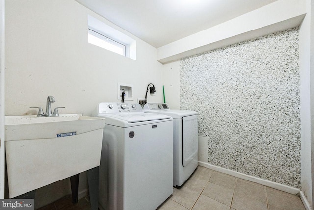 laundry room with a sink, separate washer and dryer, light tile patterned flooring, baseboards, and laundry area