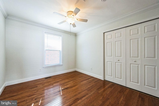 unfurnished bedroom with a closet, visible vents, ornamental molding, and wood finished floors