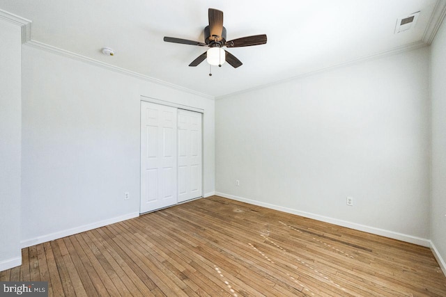 unfurnished bedroom with visible vents, baseboards, ornamental molding, a closet, and light wood-type flooring