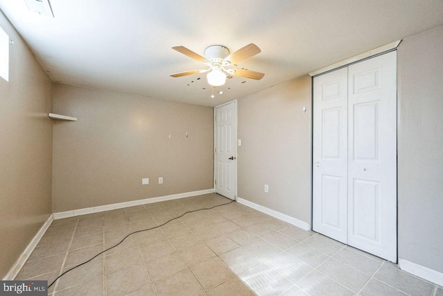 unfurnished bedroom featuring light tile patterned floors, a closet, baseboards, and ceiling fan