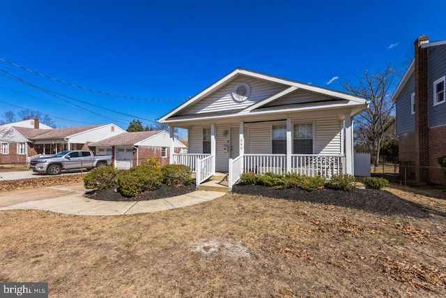 view of front of home featuring a porch and fence