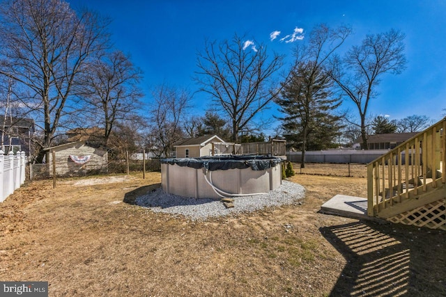 view of yard featuring stairs, a fenced in pool, and fence