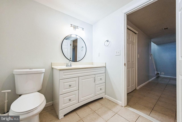 bathroom featuring baseboards, toilet, vanity, and tile patterned flooring