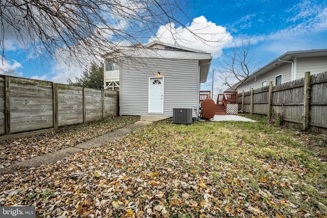 rear view of property featuring a fenced backyard and central AC unit