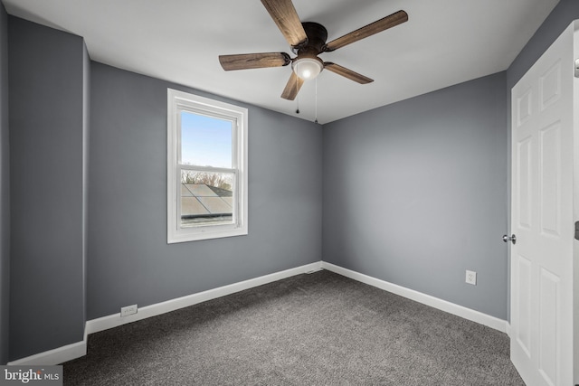 carpeted empty room featuring ceiling fan and baseboards