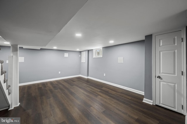 below grade area featuring dark wood-style floors, recessed lighting, and baseboards