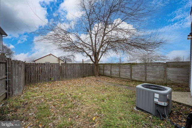 view of yard with a fenced backyard and central AC unit