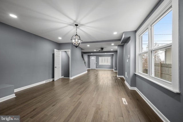 unfurnished living room with dark wood-type flooring, recessed lighting, visible vents, and baseboards