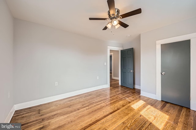 unfurnished bedroom with light wood-type flooring, ceiling fan, and baseboards