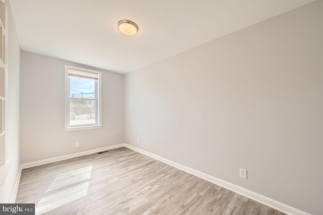 empty room with light wood finished floors and baseboards