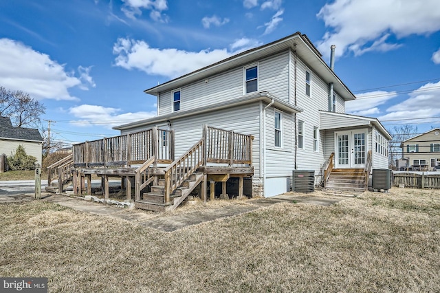 rear view of property with entry steps, a lawn, central AC, and french doors