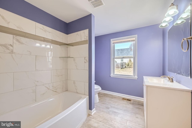 bathroom with visible vents, toilet, vanity, and baseboards