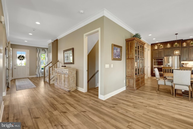 foyer featuring crown molding, recessed lighting, baseboards, and light wood-style floors