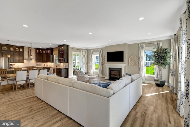 living room with recessed lighting, light wood finished floors, and a wealth of natural light