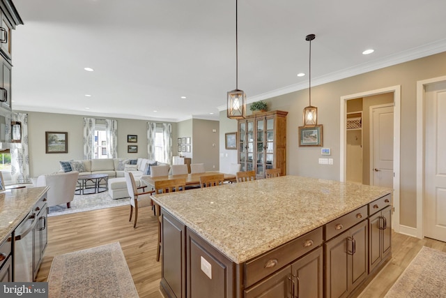 kitchen with stainless steel dishwasher, recessed lighting, hanging light fixtures, and light wood-type flooring