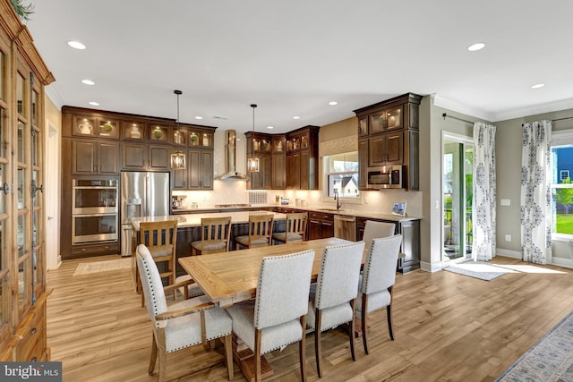 dining space featuring light wood-style floors, ornamental molding, baseboards, and recessed lighting